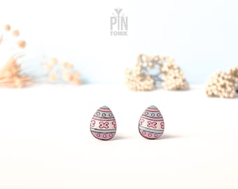 Könnte beinhalten: Ein Paar pastellrosa und blaue Osterei-Ohrringe. Die Ohrringe sind aus Holz und haben ein bemaltes Design aus rosa und blauen Streifen, weißen Punkten und rosa Blumen.