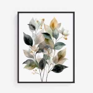 May include: A framed watercolor print featuring a botanical design. The artwork showcases a cluster of leaves in shades of green, gray, and gold, with delicate white flowers. The print is set against a white background and framed in a black border.