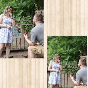 May include: A white sleeveless dress with a blue floral pattern, featuring ruffled shoulder straps and a square neckline. The dress is worn by a person standing near a metal fence while another person kneels, holding a small red ring box.