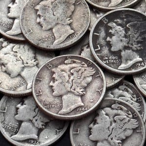 May include: A collection of silver Mercury dimes, featuring the profile of a woman with winged hair. The coins display the inscriptions "IN GOD WE TRUST" and various dates, including 1917, 1936, 1943, and 1944.