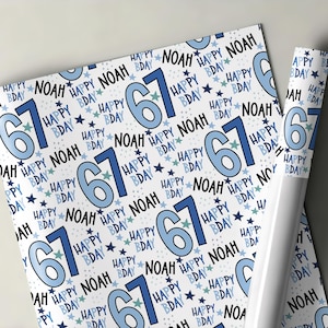 May include: White wrapping paper featuring a repeating pattern of the number 61 in blue, the name "Noah", and the words "Happy Bday" with star accents. A rolled up section of the paper is visible.