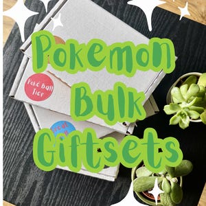 May include: Two white cardboard shipping boxes stacked on a black surface, featuring circular stickers labelled Poké Ball Tier and Great Ball. The text Pokemon Bulk Giftsets is overlaid in green. Two small green succulent plants are visible nearby.