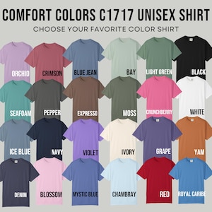 May include: A color chart for Comfort Colors C1717 unisex shirts featuring twenty-four short-sleeve t-shirts in various shades including orchid, crimson, blue jean, bay, light green, black, seafoam, pepper, expresso, moss, crunchberry, white, ice blue, navy, violet, ivory, grape, yam, denim, blossom, mystic blue, chambray, red, and royal caribe.