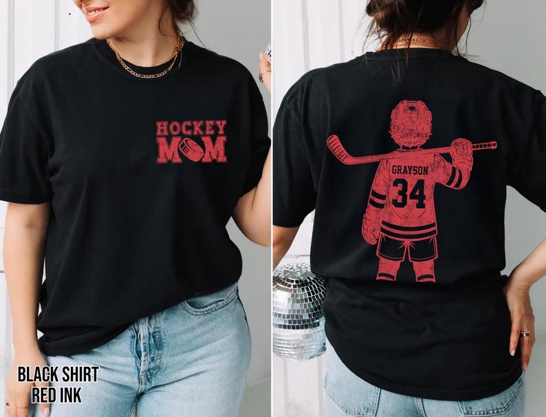 May include: Black t-shirt with red ink. The front features "Hockey Mom" with a hockey puck graphic. The back displays a red hockey player graphic with the name "Grayson" and the number "34".