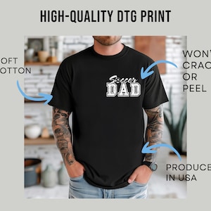 May include: Black t-shirt with the text "Soccer Dad" in white block letters. The shirt is made of soft cotton and is produced in the USA. The print is high-quality and won't crack or peel.