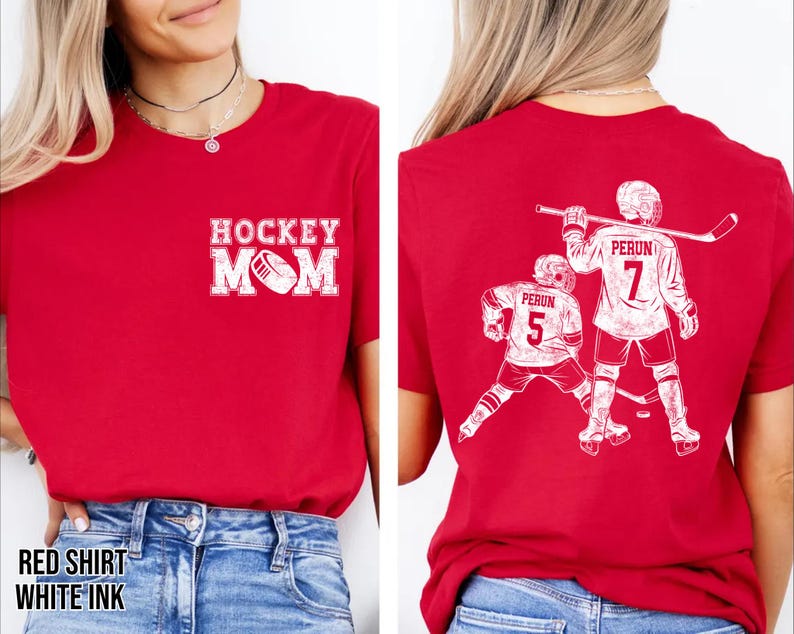 May include: Red t-shirt with white graphic text and design. The front of the shirt says "HOCKEY MOM" with a hockey puck graphic. The back of the shirt features two hockey players with the text "PERUN" and the number "7" and "5".