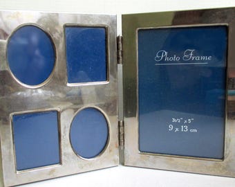 May include: A silver metal photo frame with multiple openings. The frame has four openings of different shapes, two squares and two circles, and a larger rectangular opening. The text "Photo Frame" is visible. The frame dimensions are 3 1/2" x 5" (9 x 13 cm).