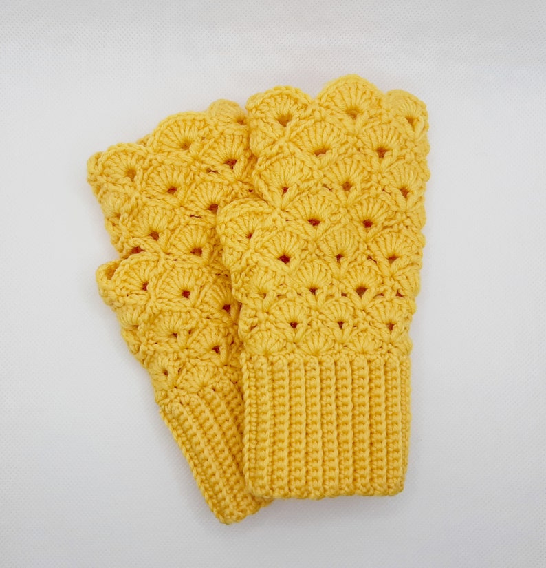 May include: A pair of yellow crocheted fingerless gloves with a scalloped edge and a textured pattern.