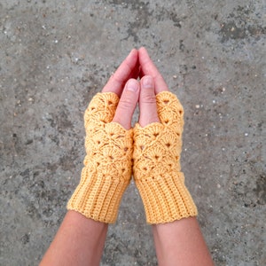 May include: A pair of yellow crocheted fingerless gloves with a lacy pattern.
