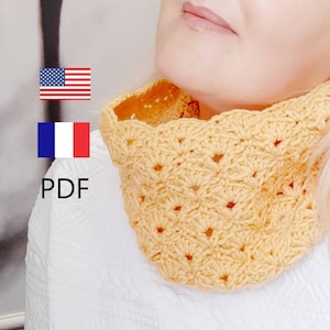 Può includere: Un scaldacollo all'uncinetto giallo con un motivo a punto quadrato. Il modello è disponibile in inglese e francese.