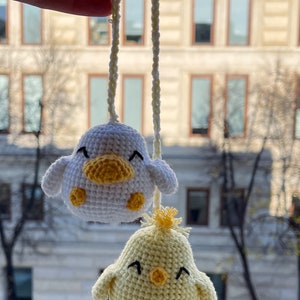 Crochet PDF Pattern for little baby yellow chicken with with yellow orange feathers and white baby duck with orange beak. These two baby animals are joined with crocheted chain to be used as car rear mirror hanger, or to be hanged anywhere in general