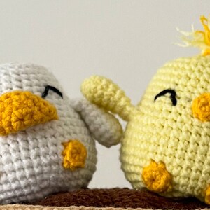 Crochet PDF Pattern for little baby yellow chicken with with yellow orange feathers and white baby duck with orange beak. These two baby animals are joined with crocheted chain to be used as car rear mirror hanger, or to be hanged anywhere in general