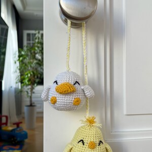 Crochet PDF Pattern for little baby yellow chicken with with yellow orange feathers and white baby duck with orange beak. These two baby animals are joined with crocheted chain to be used as car rear mirror hanger, or to be hanged anywhere in general