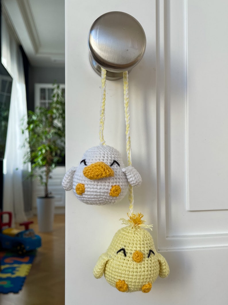 Crochet PDF Pattern for little baby yellow chicken with with yellow orange feathers and white baby duck with orange beak. These two baby animals are joined with crocheted chain to be used as car rear mirror hanger, or to be hanged anywhere in general
