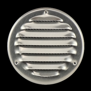 Op de afbeelding: Een ronde, geborsteld metalen ventilatieafdekking met horizontale lamellen. De ventilatie heeft een reeks gelijkmatig verdeelde, gebogen openingen voor de luchtstroom. Het metaal heeft een licht reflecterend oppervlak.