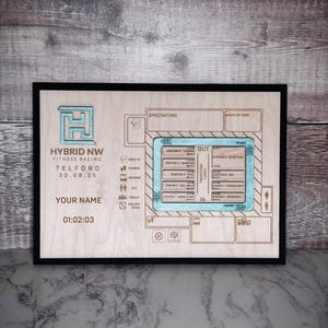 May include: Wooden plaque with a black frame featuring a fitness racing map. The map includes a blue and white design with text such as "Hybrid NW Fitness Racing Telford" and "Your Name". The time "01:02:03" is also displayed.