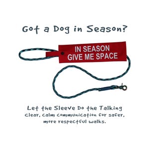 May include: A red tag with the text "IN SEASON GIVE ME SPACE" attached to a teal and black rope leash. The text "Got a Dog in Season?" and "Let the Sleeve Do the Talking" are also visible.