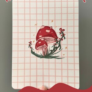 May include: A printable cardstock insert with a pink and white grid pattern. The insert features an original illustration of red mushrooms with green leaves and gold glitter accents. The text "Pattern D" is printed at the bottom of the insert.