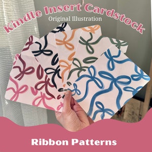 May include: Five different patterned cards with abstract ribbon designs in pink, black, orange, green, and blue. The cards are labelled "Kindle Insert Cardstock Original Illustration" and "Ribbon Patterns".