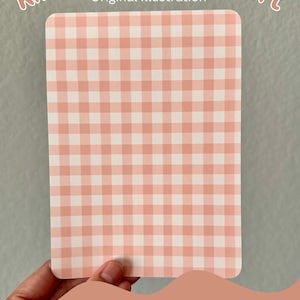 May include: A pink and white gingham pattern cardstock insert for a Kindle. The insert is held in a hand and the text "Pattern A" is visible at the bottom of the image.