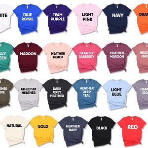 May include: A variety of t-shirt colors, including white, true royal, team purple, light pink, navy, orange, kelly green, maroon, heather peach, heather raspberry, heather maroon, heather mauve, heather olive, athletic heather, dark grey heather, heather deep teal, light blue, heather storm, natural, gold, heather navy, black, and red.