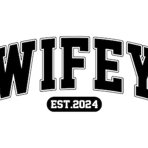 May include: Black and white graphic design with the word "WIFEY" in a bold, arched font. Below the word is the text "EST. 2024" in a smaller, oval-shaped font. The design is simple and modern.