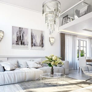 May include: A living room featuring a large white sectional sofa, a glass coffee table with a flower vase, a tufted gray armchair, and a tiered crystal chandelier. Two framed abstract paintings hang on the wall above the sofa.