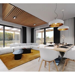 Pu&ograve; includere: Una zona soggiorno e pranzo con un divano angolare bianco su un grande tappeto giallo senape, due tavolini ovali neri e un tavolo da pranzo in legno chiaro con sedie bianche. Il soffitto presenta listelli in legno e lampade a sospensione.