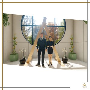 May include: Two miniature figurines, one in a black suit and one in a black dress, stand before a large wooden A-frame structure. Behind them is a circular window with a view of trees. Two green planters with plants flank the scene.