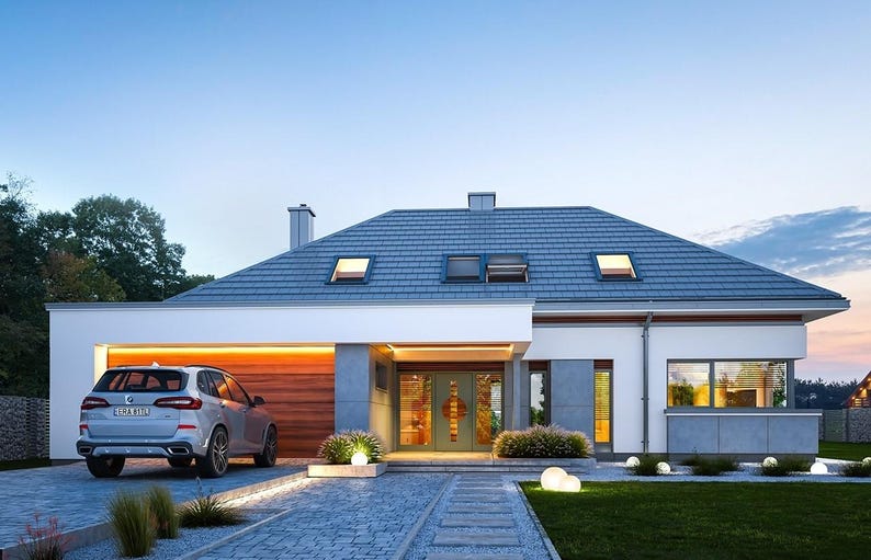 May include: A modern one-story house with a gray tiled roof, white exterior walls, and gray stone accents. A silver SUV is parked in the driveway next to a wooden garage door. The entrance features a glass door, and the front yard has small shrubs.