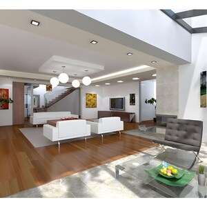 May include: A spacious living room featuring white sofas, two grey tufted chairs, a glass coffee table with a green bowl of fruit, wooden flooring, recessed ceiling lighting, a central pendant light fixture, and various wall art pieces.