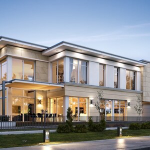 Nighttime view of a luxurious two-story home illuminated with warm lights, emphasizing its large windows and cozy outdoor seating area.