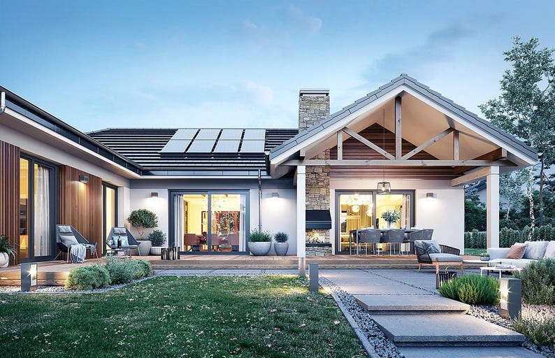May include: A single-story house with a gabled roof, solar panels, and a stone chimney. The exterior features wood paneling and white walls. A covered patio area includes outdoor furniture, a fireplace, and glass sliding doors.