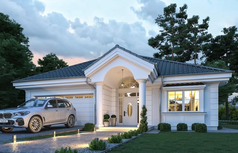 May include: A single-story white house with a dark gray tiled roof, a front porch supported by two white columns, and a white garage door. A silver SUV is parked on the paved driveway in front of the garage, with green lawn and trees.