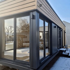 Modern modular house design with large glass windows and wooden cladding, ideal for contemporary house plans, tiny home plans, or barndominium layouts. Perfect for flexible and sustainable living solutions.