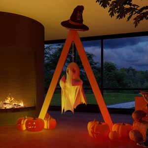 May include: A tall orange A-frame structure with a dark brown witch hat perched on top and a white ghost figure hanging from the center. Several orange jack-o'-lanterns with carved faces are arranged around the base of the frame.