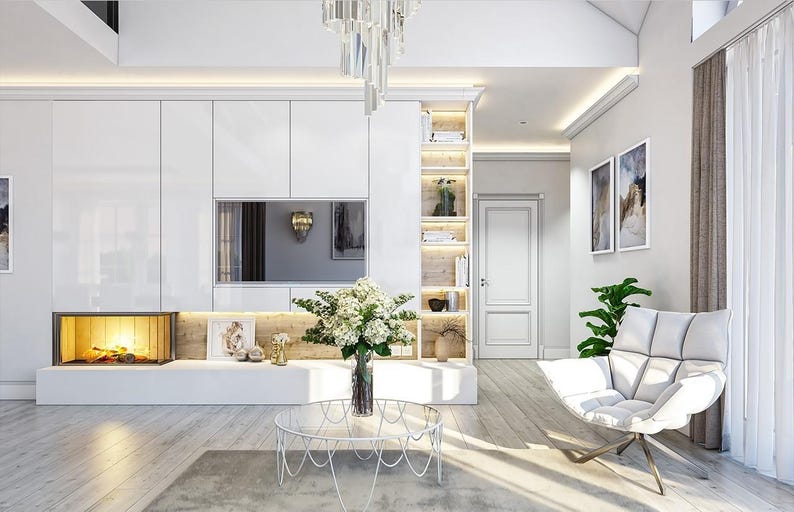 May include: A living room featuring a white wall unit with a built-in fireplace, a television, and open shelving. A glass coffee table with a white metal base sits in the center, holding a vase of white flowers near a white armchair.