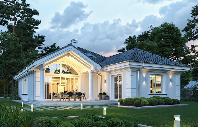 May include: A single-story white house with a dark tiled roof, featuring a large arched glass facade supported by two white columns, a covered patio with outdoor dining furniture, and exterior wall lighting in a landscaped garden.
