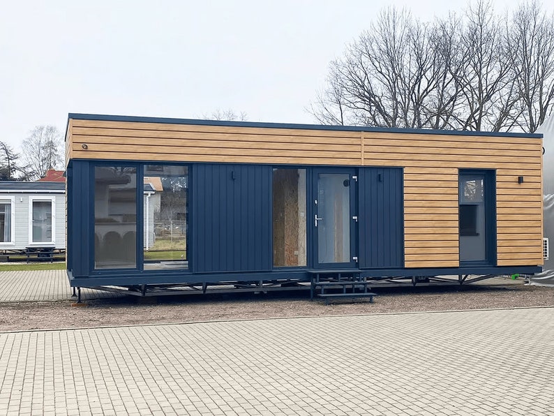Contemporary modular home with sleek wooden panels and navy accents, designed for flexibility and modern living. Ideal for tiny home plans, townhouse plans, or small cabin layouts with customizable floor plans.
