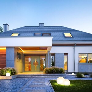 May include: A modern single-story house with a gray tiled roof, white exterior walls, and wood paneling on the garage. The entrance features a light green door with glass panels, illuminated by warm LED strip lighting and spherical garden lights.