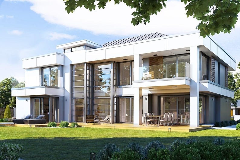 May include: A modern, two-story house with a white exterior, large glass windows, and a flat roof. The house has a balcony, a patio with a dining table and chairs, and a well-maintained green lawn. The sky is blue with some clouds.