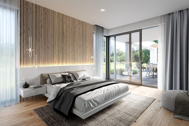 May include: A bedroom featuring a low-profile white bed with gray and white bedding, positioned against a wall with vertical wood slats and integrated lighting. A floating white nightstand, a gray area rug, and floor-to-ceiling windows.
