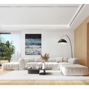 Spacious living room with a white sectional sofa, wooden accents, and natural light streaming in, an essential part of modern house plans and villa designs