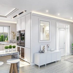 May include: A bright kitchen and living area featuring white cabinetry, a gray marble-topped island with two white-topped wooden stools, a white sideboard with framed art, a wall mirror, and a green potted plant on a light wood floor.