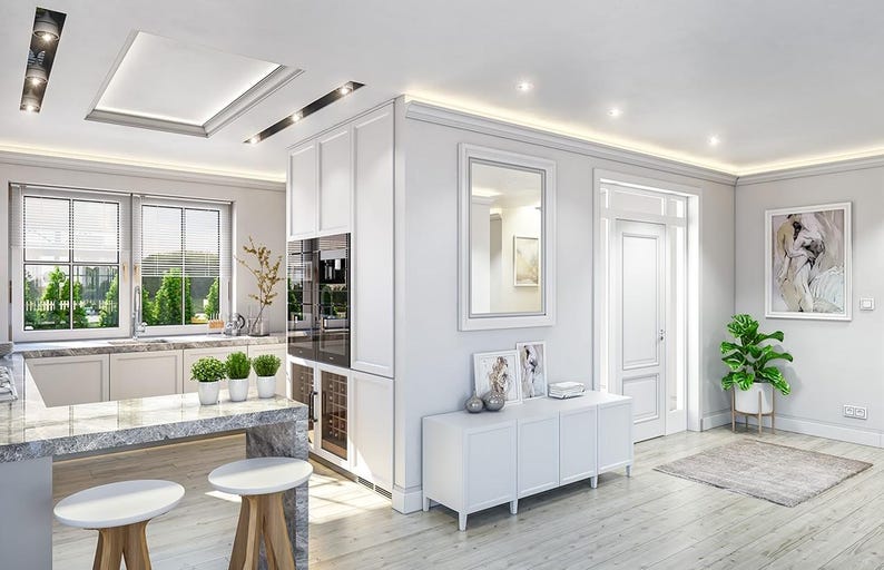 May include: A bright kitchen and living area featuring white cabinetry, a gray marble-topped island with two white-topped wooden stools, a white sideboard with framed art, a wall mirror, and a green potted plant on a light wood floor.