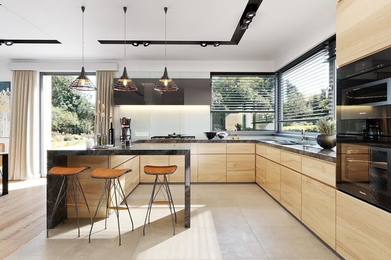 May include: A modern kitchen featuring light wood cabinetry, a dark marble countertop, and three bar stools with tan leather seats and black metal wire bases. Three black pendant lights hang above the kitchen island.