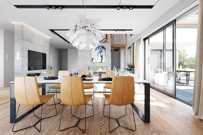 May include: A dining room featuring a white rectangular table with black metal legs, surrounded by six tan leather chairs with thin black metal frames. A large white multi-layered pendant light hangs above the table, and a television is mounted on a concrete wall.
