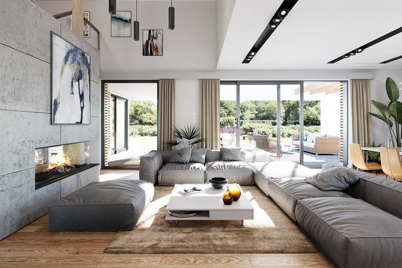 May include: A spacious living room featuring a large gray modular sofa, a low white rectangular coffee table, and a fireplace built into a gray concrete wall. The room includes a brown area rug, wooden flooring, and large glass sliding doors.