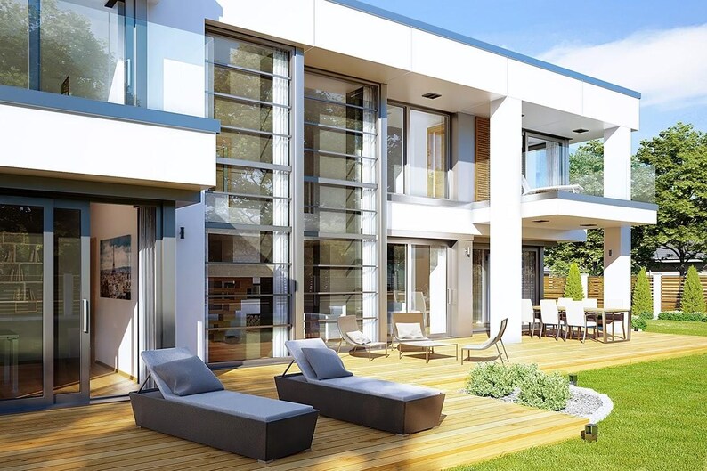 May include: Exterior view of a modern two-story house with large glass windows and doors. Two dark gray chaise lounges with light blue cushions sit on a wooden deck. A dining table and chairs are visible on a covered patio.