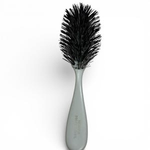 May include: A gray hairbrush with a long handle and a rounded brush head filled with black bristles. The handle has the text "HANNICK PROFESSIONAL" printed on it.
